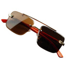 Sunglasses with red arms and gold frames on a white background