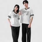 Two people wearing matching black and white striped jerseys with 'VENOM' branding on a white background.