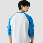 Person wearing a white and blue baseball-style shirt on a plain background
