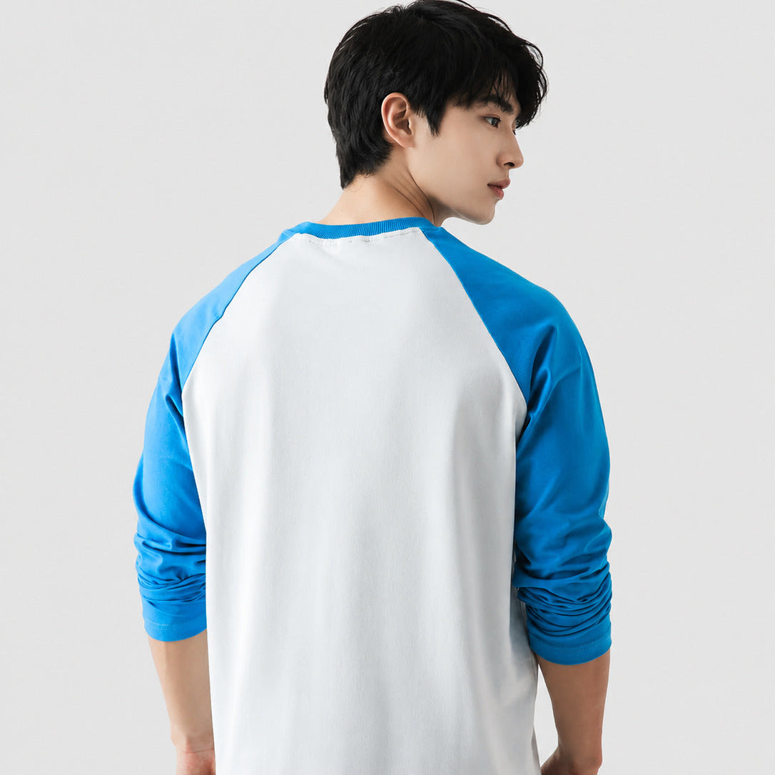 Person wearing a white and blue baseball-style shirt on a plain background
