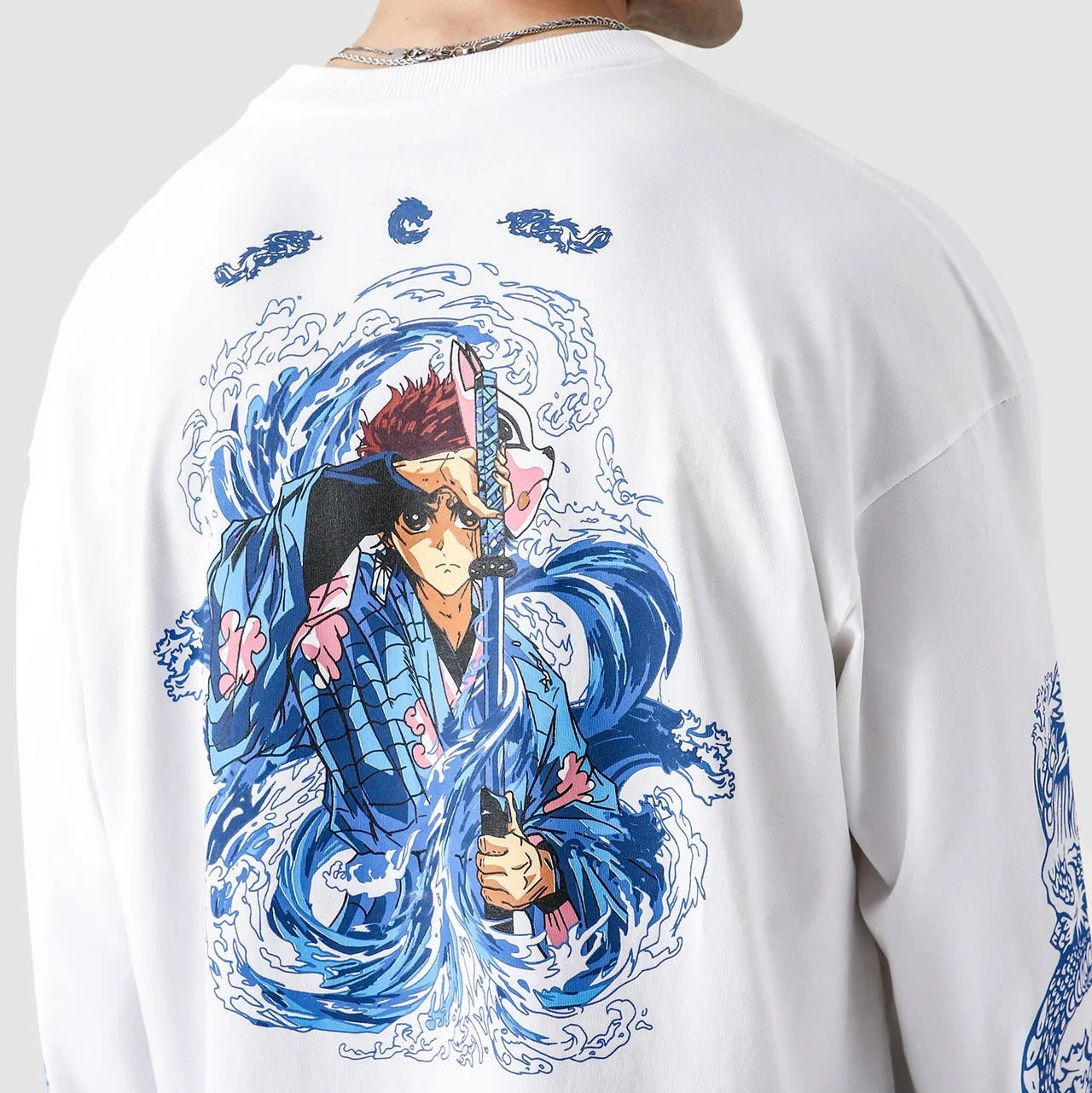 White long-sleeve shirt with a colorful graphic of a character on the back, displayed by a person.