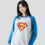 Person wearing a Superman-themed baseball shirt with blue sleeves and a white body.