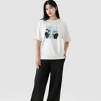 Person wearing a white t-shirt with a graphic design and black pants on a white background