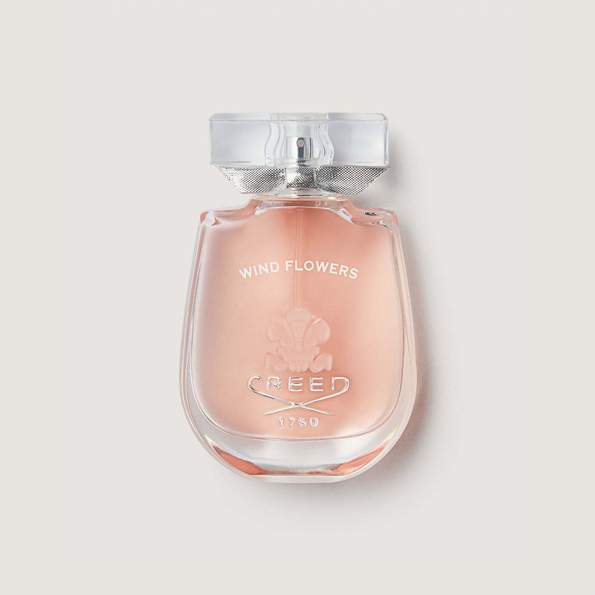 Perfume bottle labeled 'Wind Flowers' by Creed on a light gray background