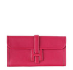 Red clutch bag with a buckle on a white background
