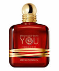 Red perfume bottle with gold cap and 'Emporio Armani' branding on a white background