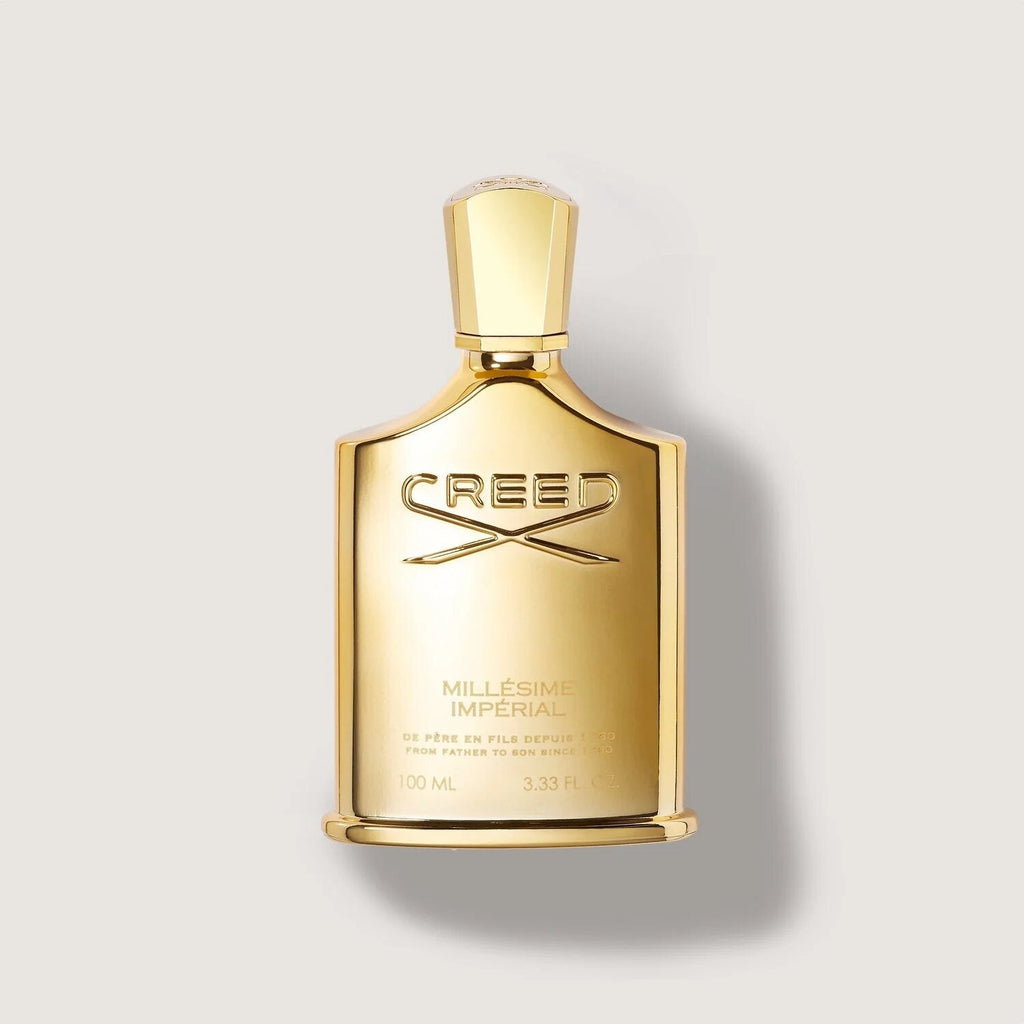 Gold Creed perfume bottle on a light gray background