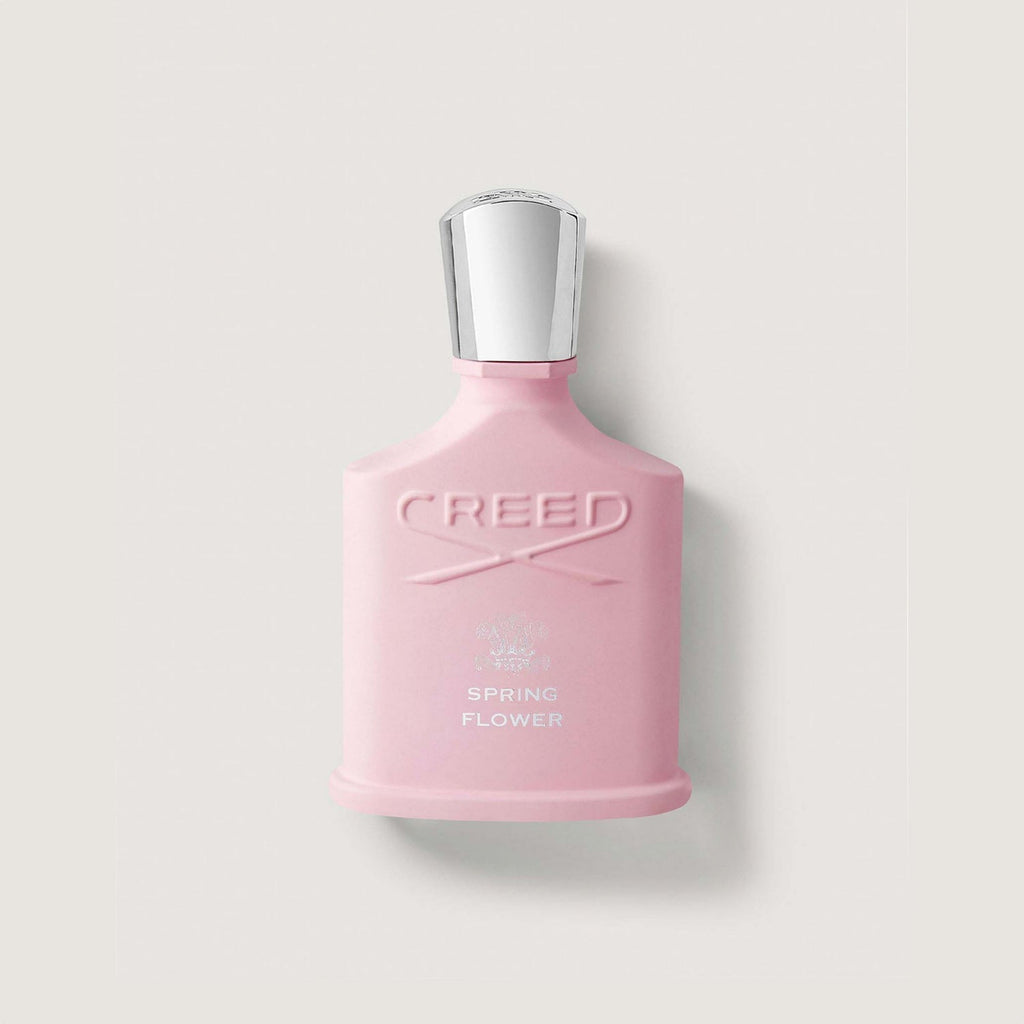 Pink Creed perfume bottle on a light gray background