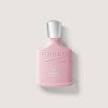 Pink Creed perfume bottle on a light gray background