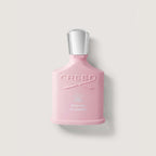 Pink Creed perfume bottle on a light gray background