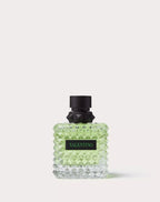Perfume bottle with black cap and green body on a white background