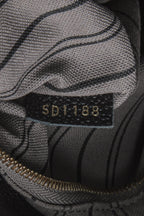 A close-up of the gold-tone logo key bell hanging from the strap