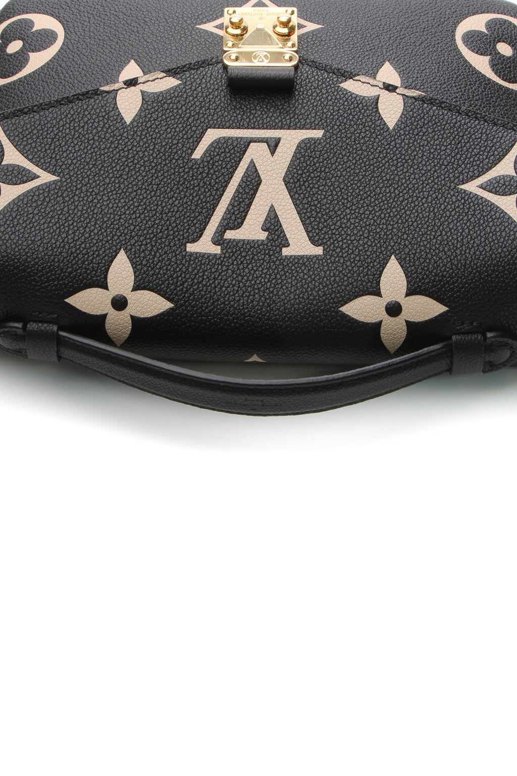 A close-up of the iconic gold-tone push-lock