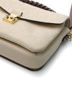 Front view of the Louis Vuitton Pochette Metis in Neige Empreinte leather