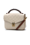 The bag carried on the forearm, highlighting its braided top handle