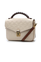 The bag carried on the forearm, highlighting its braided top handle