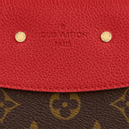 A shot of the golden clasp against the Cerise Red leather